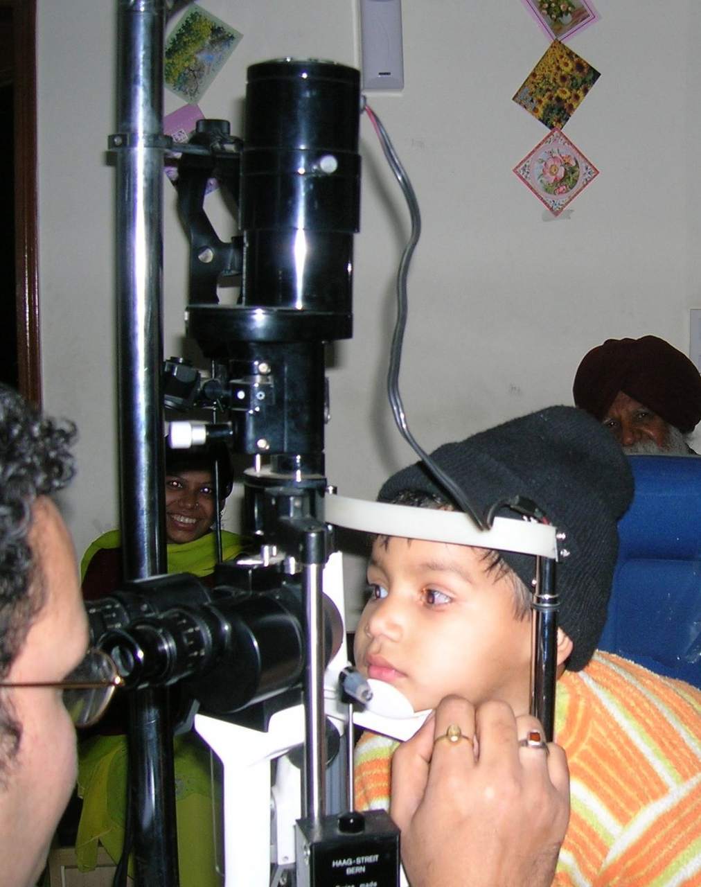 Dokter spesialis mata melakukan pemeriksaan menggunakan slit lamp untuk mendiagnosis penyebab mata merah pada pasien