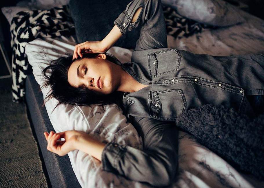 Wanita beristirahat dengan mata terpejam di kamar yang tenang saat serangan migrain