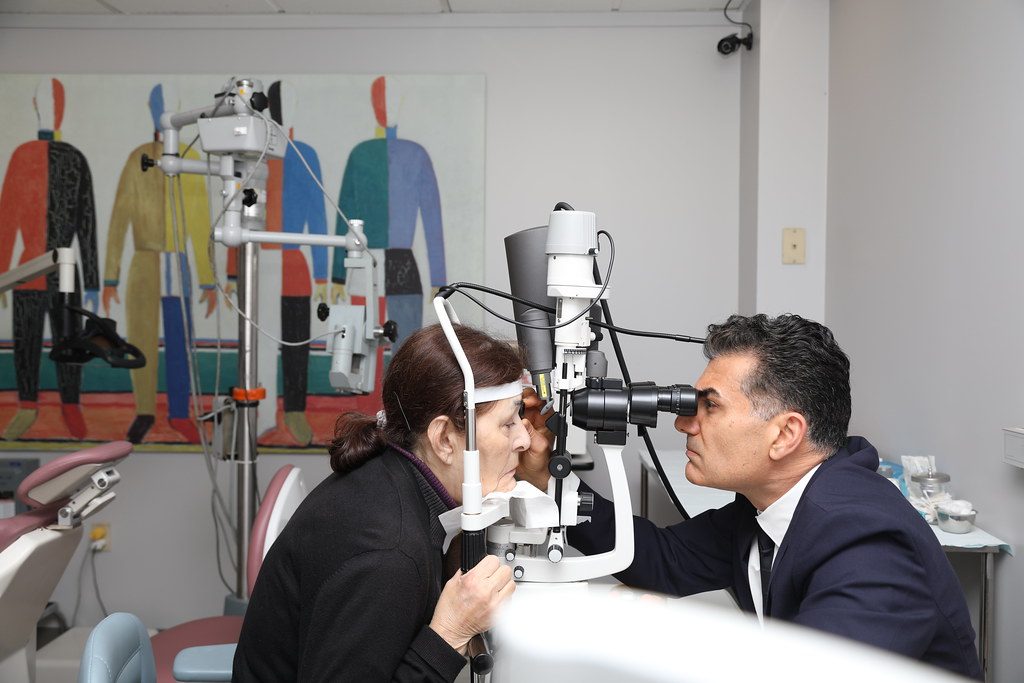 Dokter mata memeriksa mata pasien menggunakan slit lamp di klinik untuk menilai kondisi penglihatan